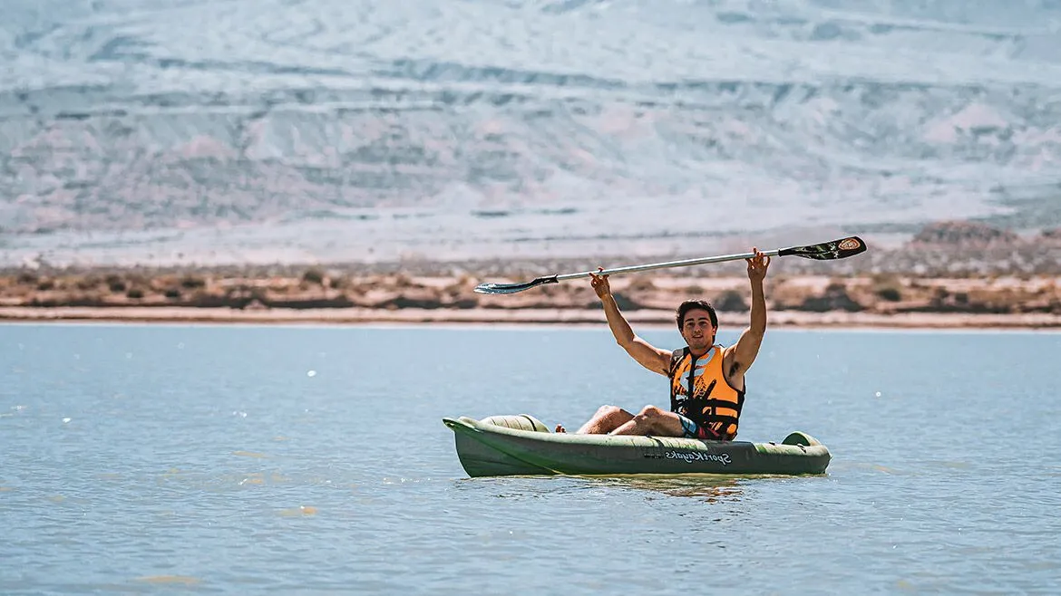 Alumno saludando desde un kayak